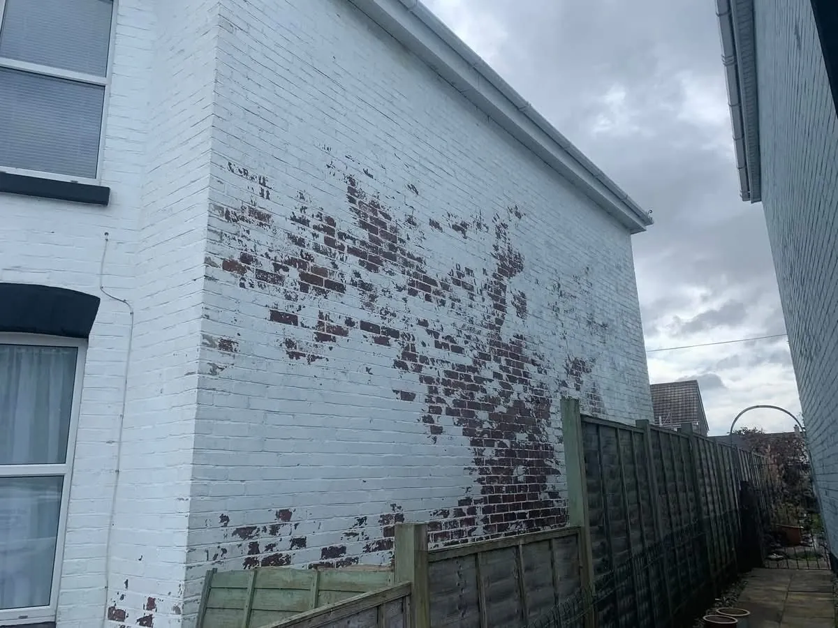 Peeling paint on a brick wall before redecoration in Perranporth